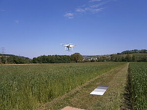 Eine Drone fliegt über das Feld.