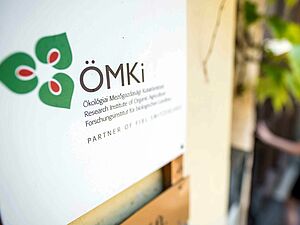 Cartello con il logo dell’ÖMKi sulla facciata di un edificio.