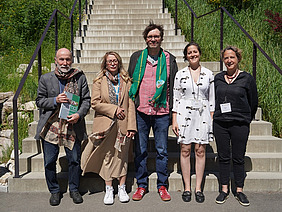 Five people in front of a staircase.