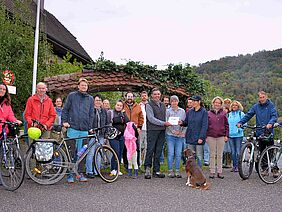 Photo de groupe avec une vingtaine de personnes, dont certaines avec des vélos