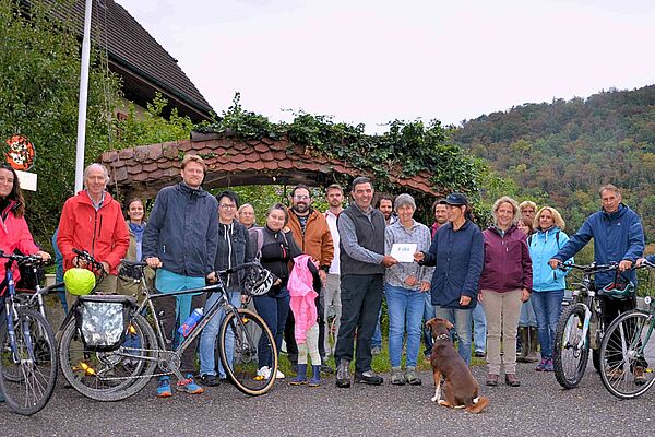 Photo de groupe avec une vingtaine de personnes, dont certaines avec des vélos