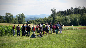 Groupe de personnes dans un champ devant une culture agricole
