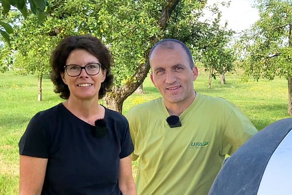 Porträt einer Frau und eines Mannes, welche auf einer Obstweide stehen.