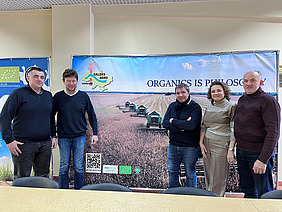 Five people in front of a poster.