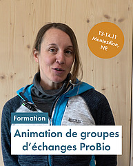 Eine Frau um die 30 schaut in die Kamera und lächelt verschmitzt. Sie trägt einen Arbeits-Pullover, hat die Haare zurückgebunden und steht vor einer Holzwand. Text: "Formation à l'animation de groupes d'échanges ProBio. 13 et 14 novembre, Montezillon, NE""