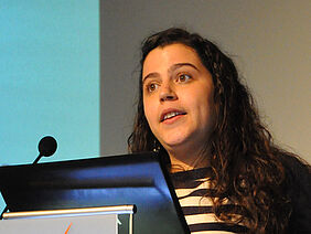 A woman is standing at a podium.