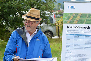 Ein Mann steht draussen vor einem Whiteboard und spricht.