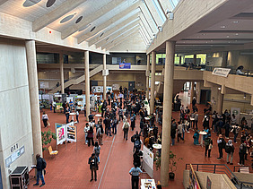View from above of participants at Tropentag 2026 in Göttingen gathered around scientific posters and in small discussion groups.