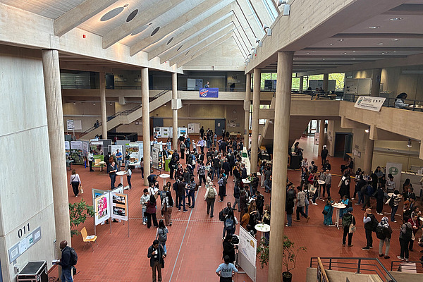 View from above of participants at Tropentag 2026 in Göttingen gathered around scientific posters and in small discussion groups.
