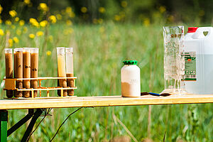 Soil samples and various containers on a bench in the field