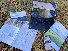 Différentes offres d'information du FiBL sont disposées dans l'herbe.