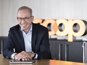 Portrait Philipp Wyss mit Coop Logo im Hintergrund