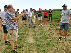 Gruppe mit etwa 20 Personen auf einem Feld.