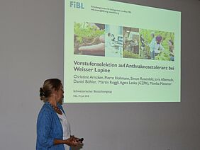 Frau erläutert die Folie einer Power-Point-Präsentation