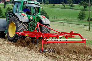 Tracteur dans le champ avec herse