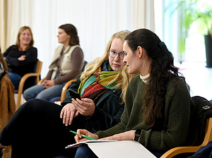 Trainees sitzen auf einer Veranstaltung.
