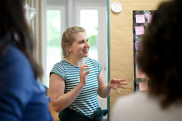 Junge Frau erklärt etwas anhand von Flipcharts.