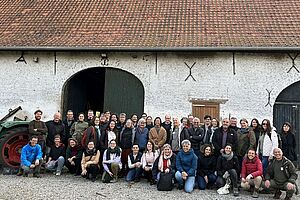 Eine Gruppe von Menschen vor einer Scheune.