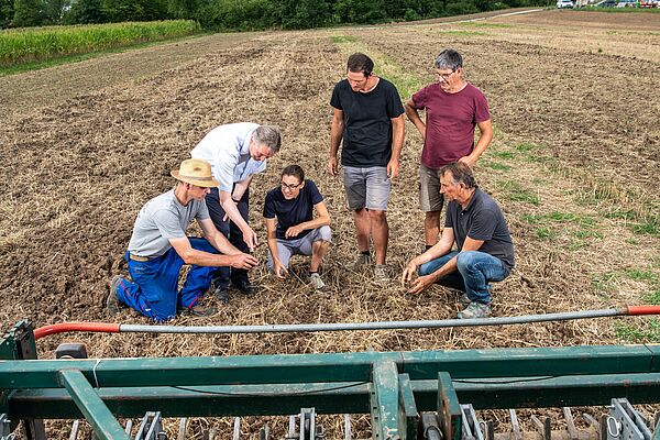 Agriculteur et les chercheurs vérifient le résultat du travail du sol.