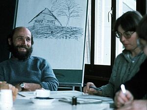 Otto Schmid et deux autres personnes assis à une table avec du matériel de travail.