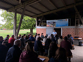 A group of people under the barn roof at the Tannenhof.