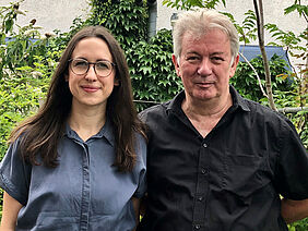 Frau und Mann stehen nebeneinander und schauen in die Kamera.