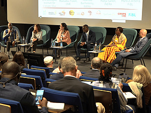 A hall with people in the audience and on stage.