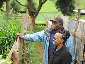 Two people standing by a fence