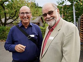 Les deux anciens directeurs sourient à la caméra