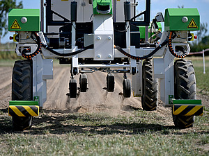Nahaufnahme einer automatischen Maschine, die über einen Acker fährt.
