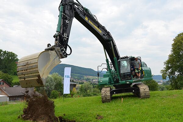 Ein Bagger leert eine Ladung Erde aus.