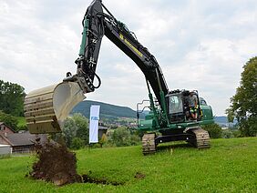 Ein Bagger leert eine Ladung Erde aus.