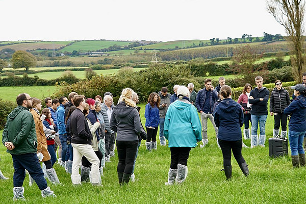 Teilnehmende bei einem Betriebsrundgang auf dem Feld.
