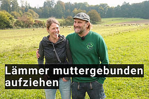 Ein Mann und eine Frau Arm in Arm auf einer Weide.