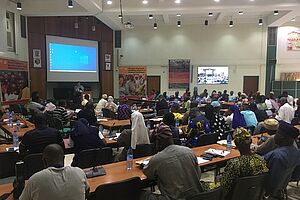 A conference room with people listening to a speaker