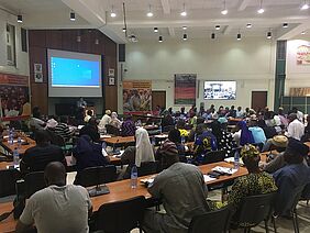 A conference room with people listening to a speaker