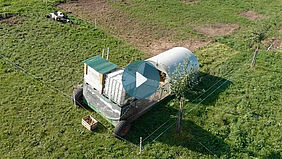 Videoscreenshot, welcher den Sau Karavan auf der Wiese zeigt.