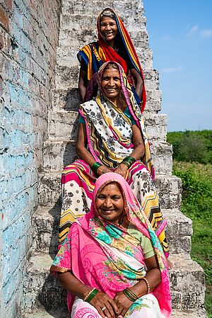 Ajodhya Bai und 2 Frauen sitzen auf einer Treppe