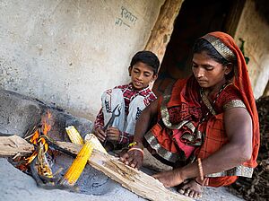 Salita Bhaware und ein Kind garen Mais am Feuer