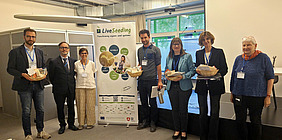 Seven people standing next to a banner.