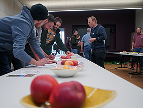 Eine Gruppe Menschen bei einer Apfeldegustation.