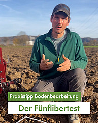 Ein Mann um die dreissig ist in der Hocke auf einem Feld und erklärt etwas direkt in die Kamera. Er gestikuliert mit den Händen und trägt Arbeitskleidung und ein FiBL-Käppi. Das Wetter ist herbstlich-sonnig, das Feld kahl. Textfeld in Grün: "Praxistipp Bodenbearbeitung: Der Fünflibertest"