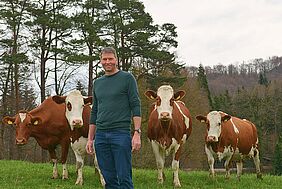 Stefan Jegge dans un pré avec des vaches