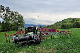 Ein Traktor bringt auf einem Feld Gülle aus.