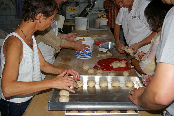 Teilnehmer eines Bäckerseminars bei der Herstellung von Teiglingen.