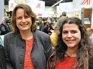 Two women at a fair, smiling at the camera.