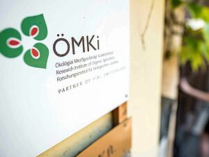 Schild an Hauswand mit Logo des ÖMKi.