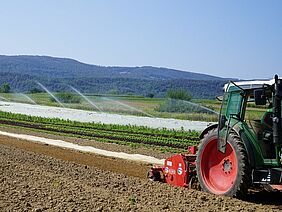 Tracteur dans un champ avec irrigation en arrière-plan