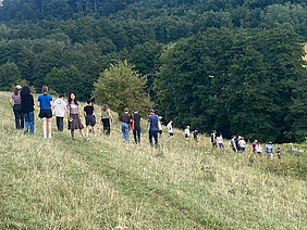 A group of young people on a meadow on a hill.