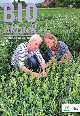 Titelseite Bioaktuell, zwei Frauen in der Hocke in einem Feld beim gemeinsamen Betrachten einer Pflanze.